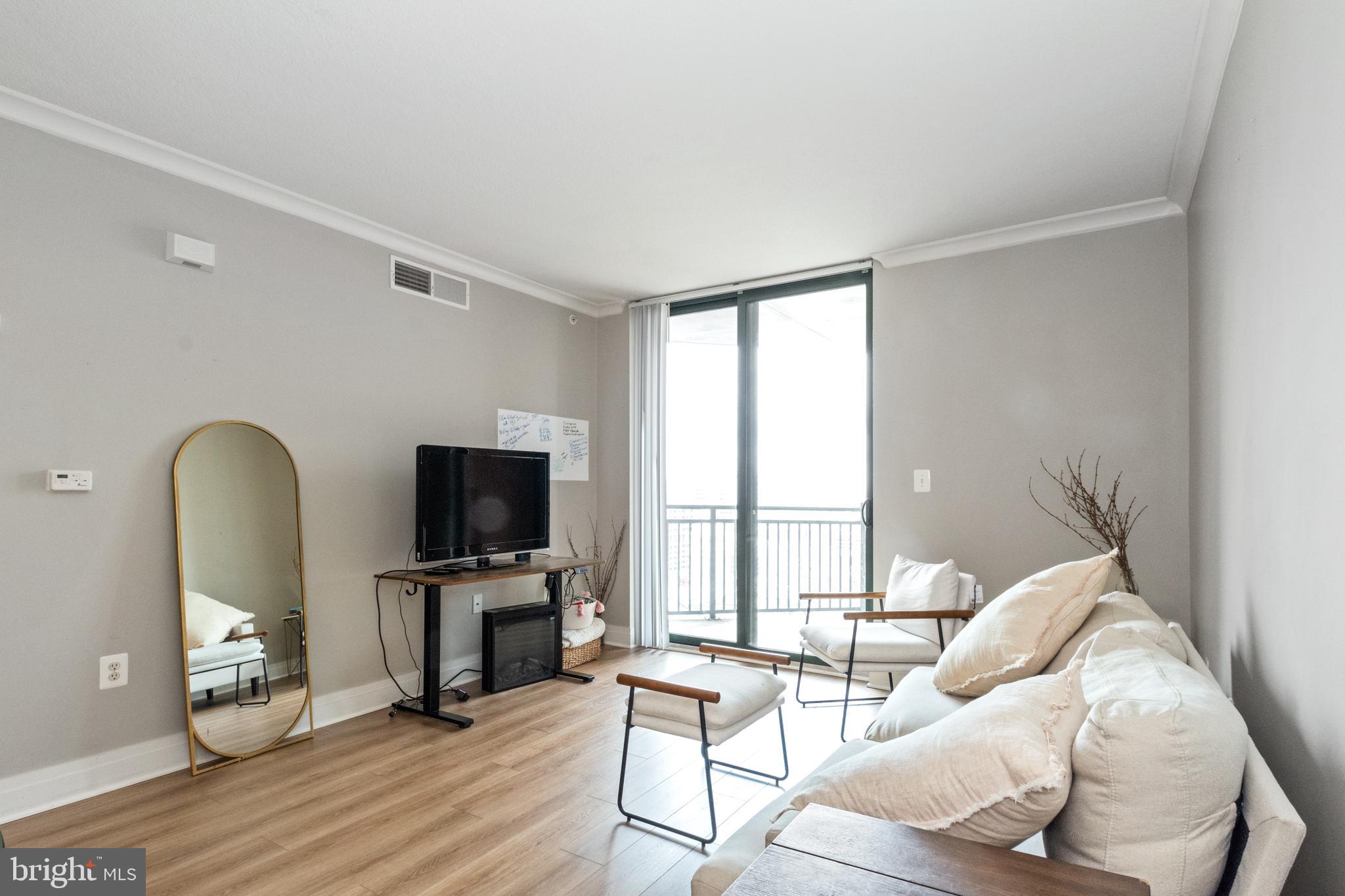 414 Water Street, Unit 2310 Baltimore, MD 21202 - Photo 11 of 31 a living room with furniture and a flat screen tv