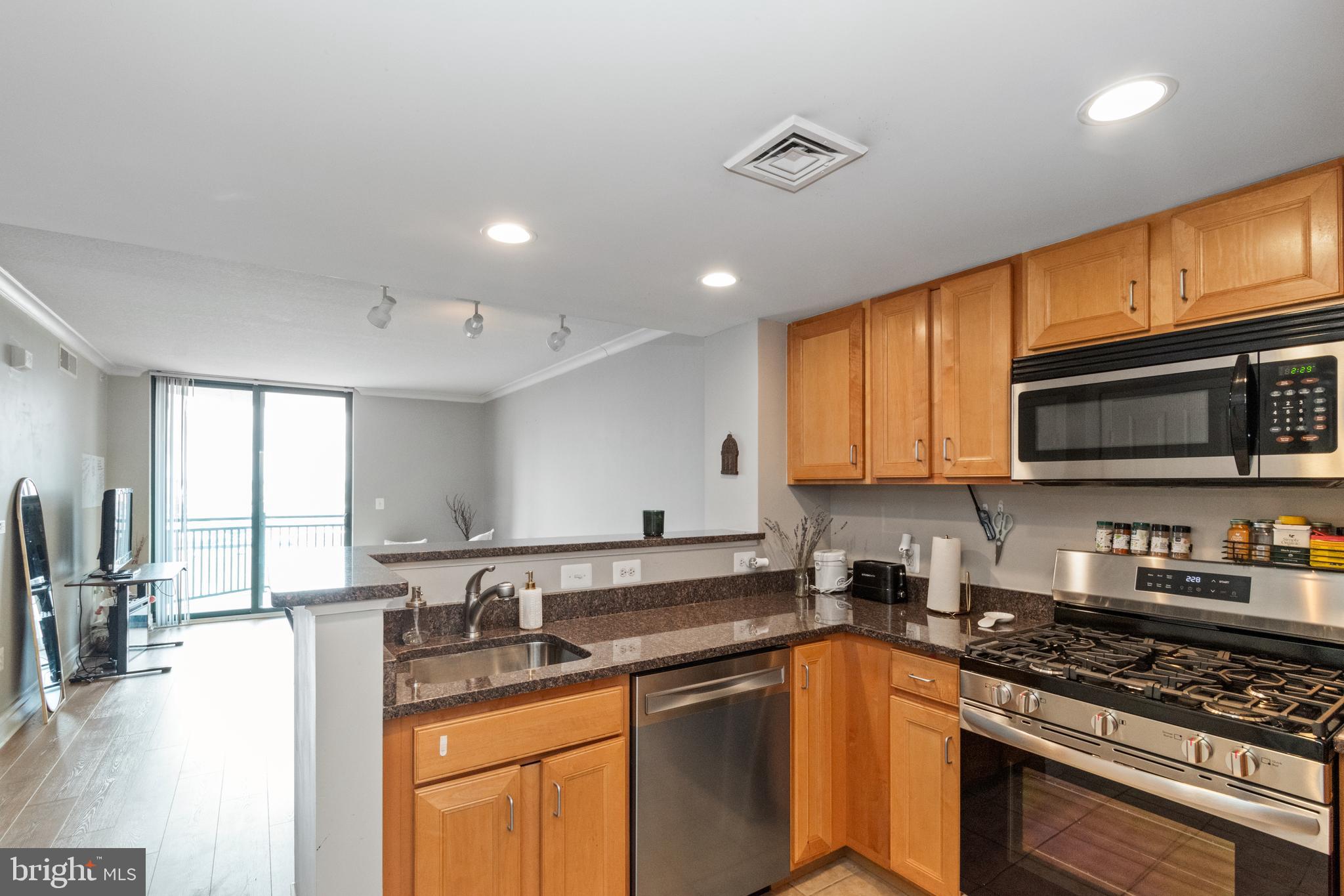414 Water Street, Unit 2310 Baltimore, MD 21202 - Photo 25 of 31 a kitchen with stainless steel appliances granite countertop a sink stove refrigerator and cabinets