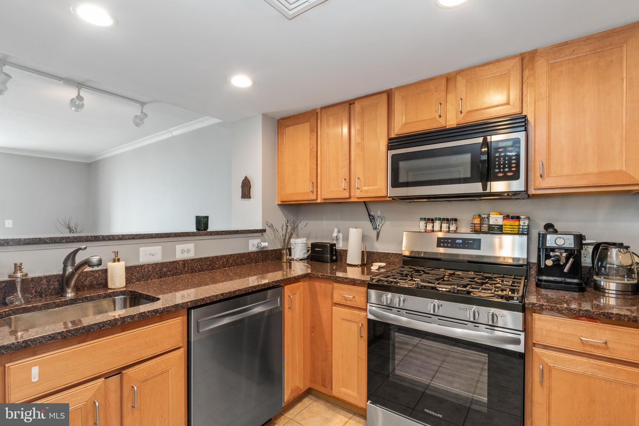 414 Water Street, Unit 2310 Baltimore, MD 21202 - Photo 3 of 31 a kitchen with stainless steel appliances granite countertop a sink stove microwave and cabinets