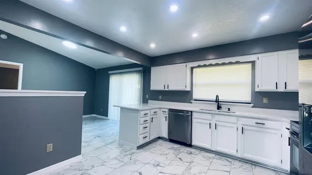a kitchen with a sink window and cabinets