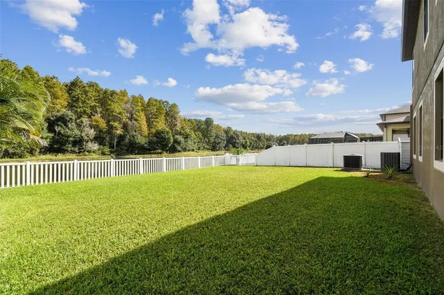 a view of an empty room with kitchen and a window