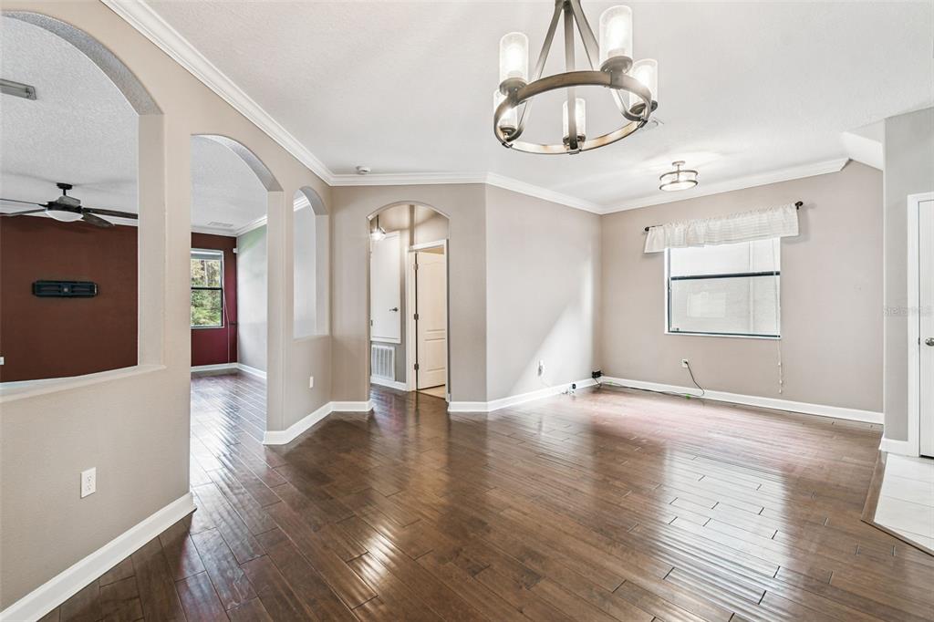 11737 Crestridge Loop New Port Richey, FL 34655 - Photo 19 of 100 a view of an empty room with wooden floor and chandelier