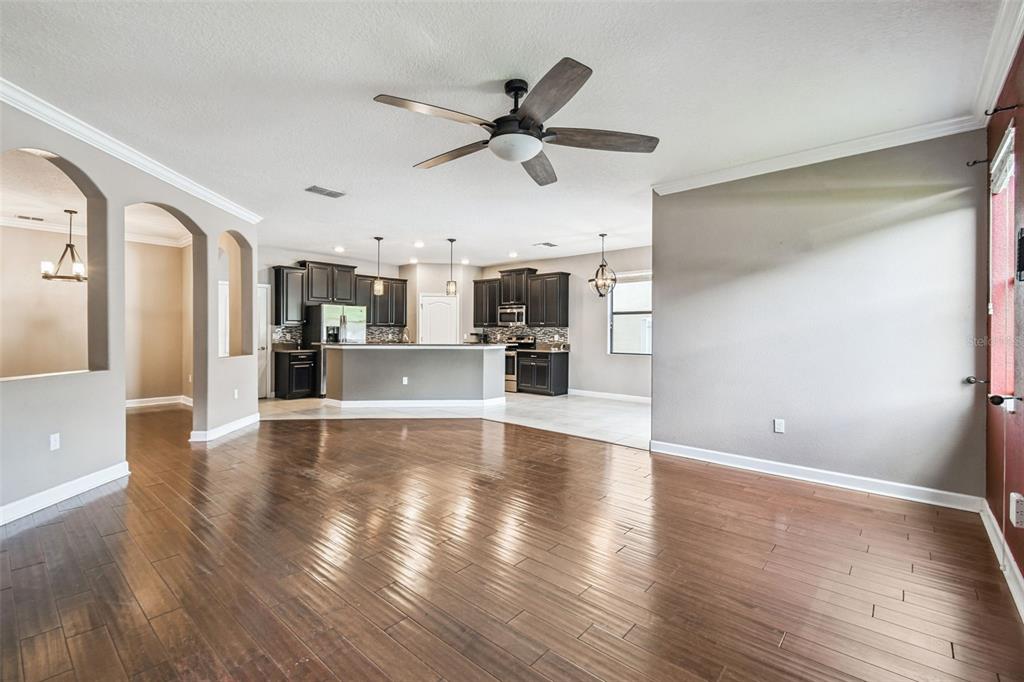11737 Crestridge Loop New Port Richey, FL 34655 - Photo 25 of 100 a view of a kitchen with wooden floor and a ceiling fan