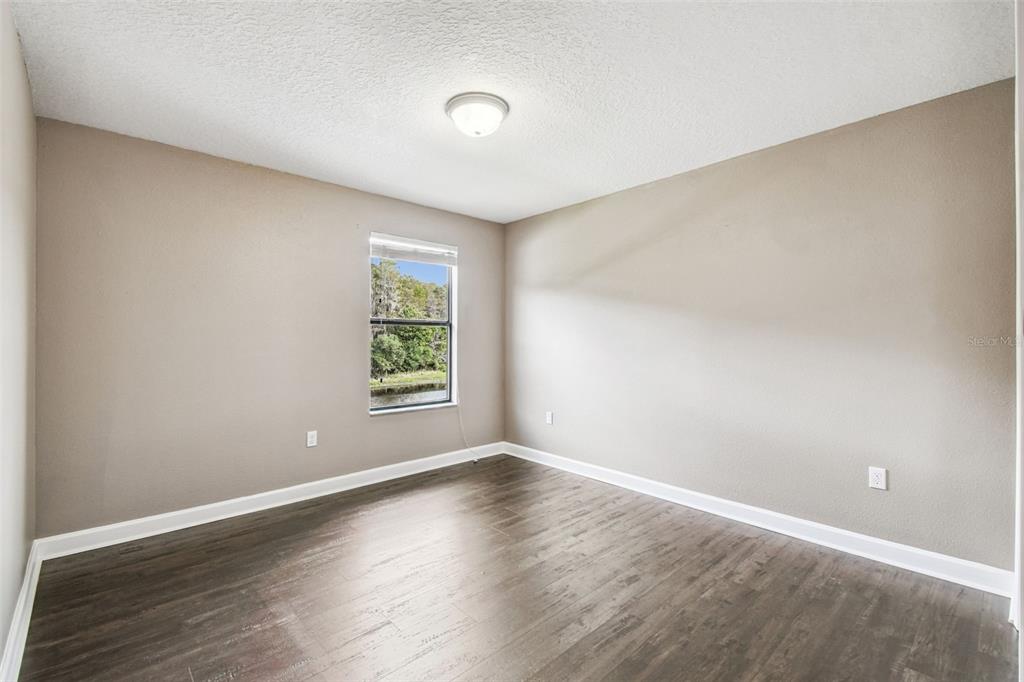11737 Crestridge Loop New Port Richey, FL 34655 - Photo 64 of 100 a view of an empty room with wooden floor and a window