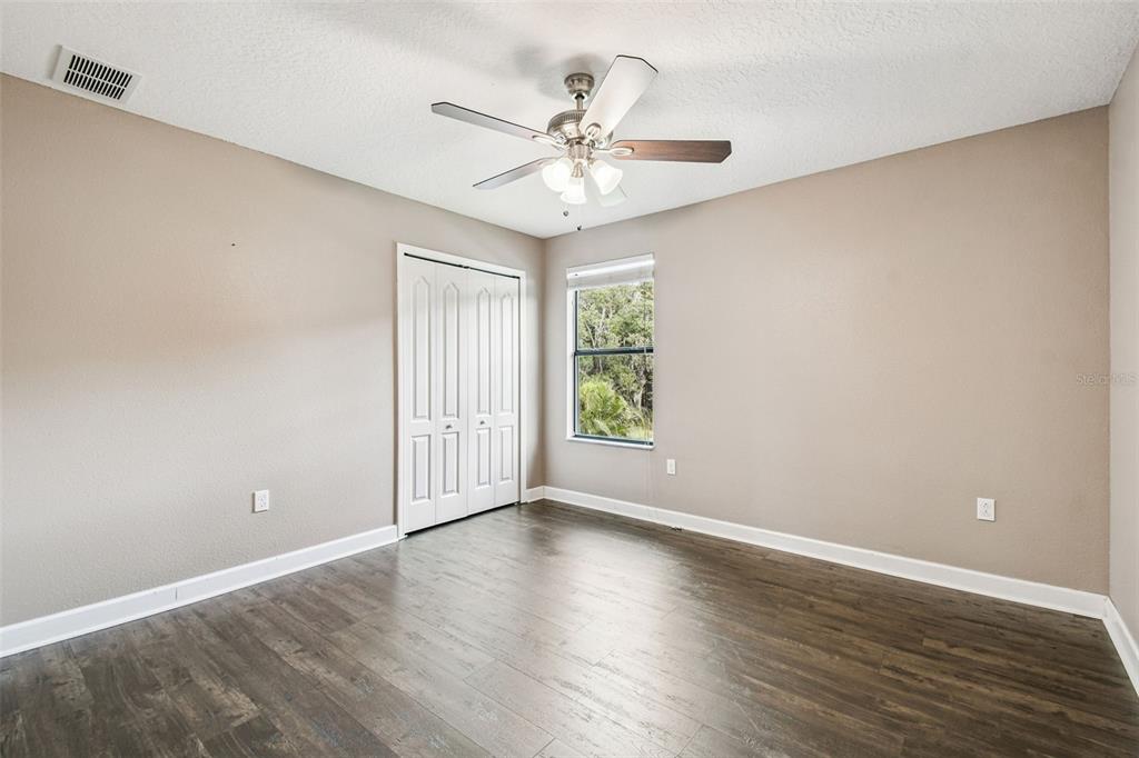 11737 Crestridge Loop New Port Richey, FL 34655 - Photo 67 of 100 a view of a room with wooden floor and a ceiling fan