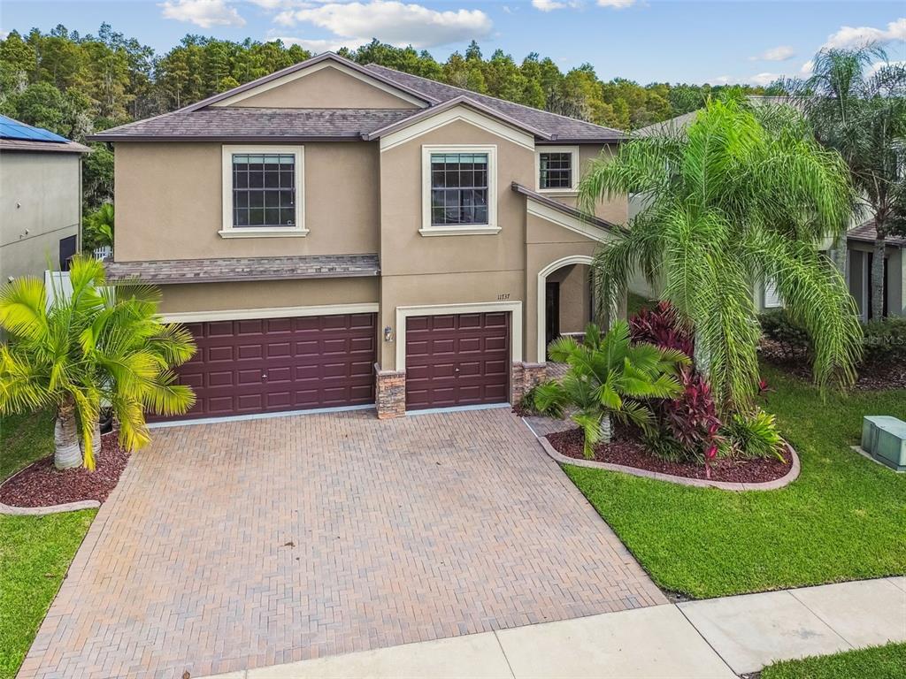 11737 Crestridge Loop New Port Richey, FL 34655 - Photo 80 of 100 a front view of a house with a garden