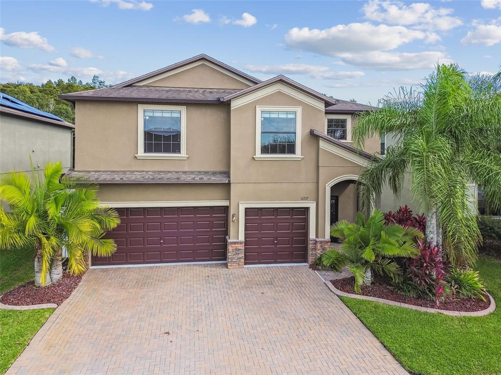 11737 Crestridge Loop New Port Richey, FL 34655 - Photo 81 of 100 a front view of a house with a yard and garage