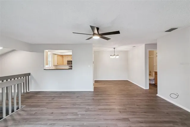 a view of a hallway with wooden floor and a ceiling fan