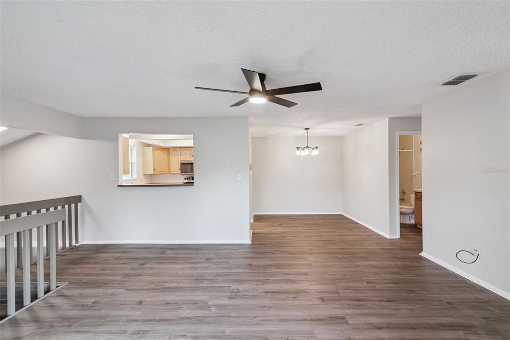 4449 Ring Neck Road, Unit C Orlando, FL 32808 - Photo 14 of 29 a view of a hallway with wooden floor and a ceiling fan