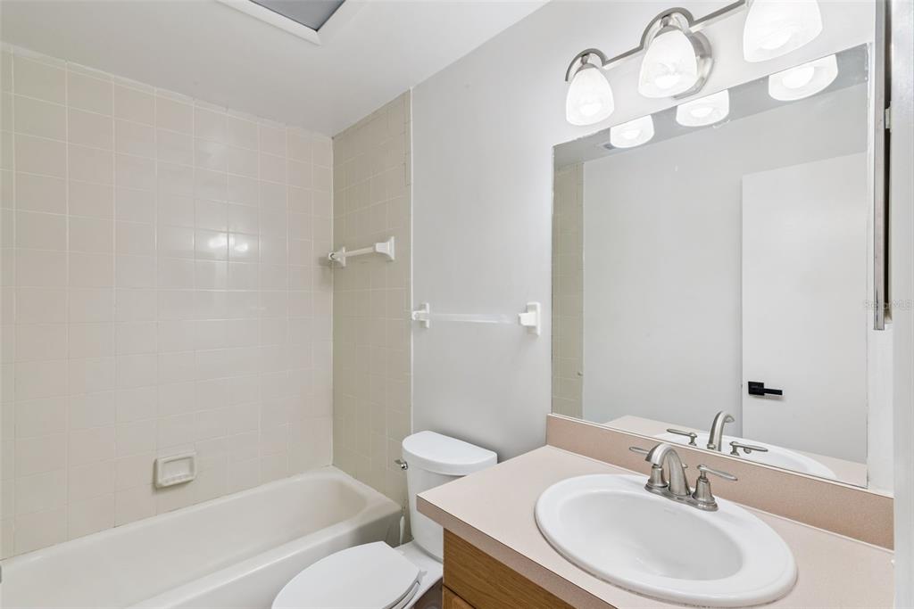 4449 Ring Neck Road, Unit C Orlando, FL 32808 - Photo 18 of 29 a bathroom with a sink a toilet a mirror and shower