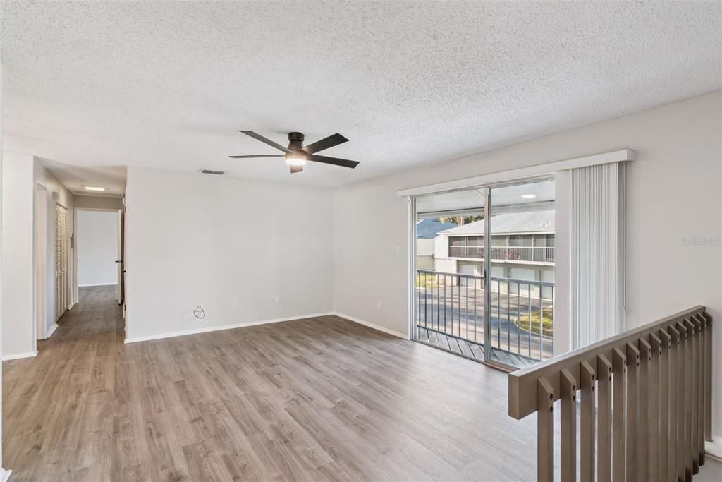 4449 Ring Neck Road, Unit C Orlando, FL 32808 - Photo 5 of 29 a view of an empty room with wooden floor and a window