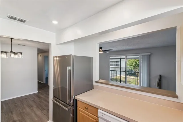 a kitchen with stainless steel appliances a refrigerator and a window