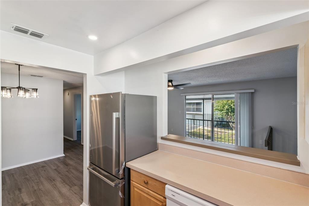 4449 Ring Neck Road, Unit C Orlando, FL 32808 - Photo 10 of 29 a kitchen with stainless steel appliances a refrigerator and a window