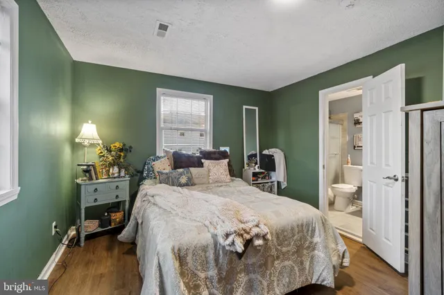 a bedroom with a bed table closet and a window