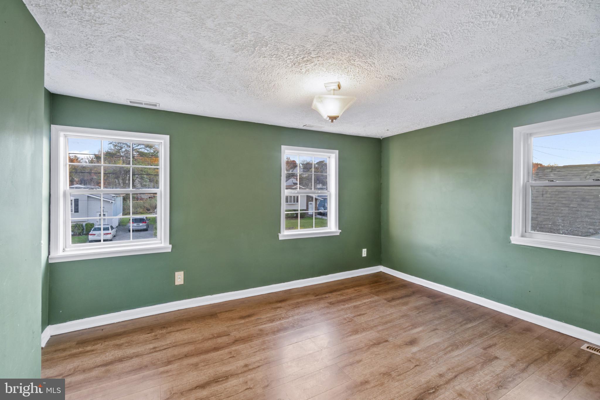 5904 Belle Grove Road Baltimore, MD 21225 - Photo 16 of 32 an empty room with wooden floor and windows