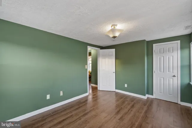 an empty room with wooden floor and closet