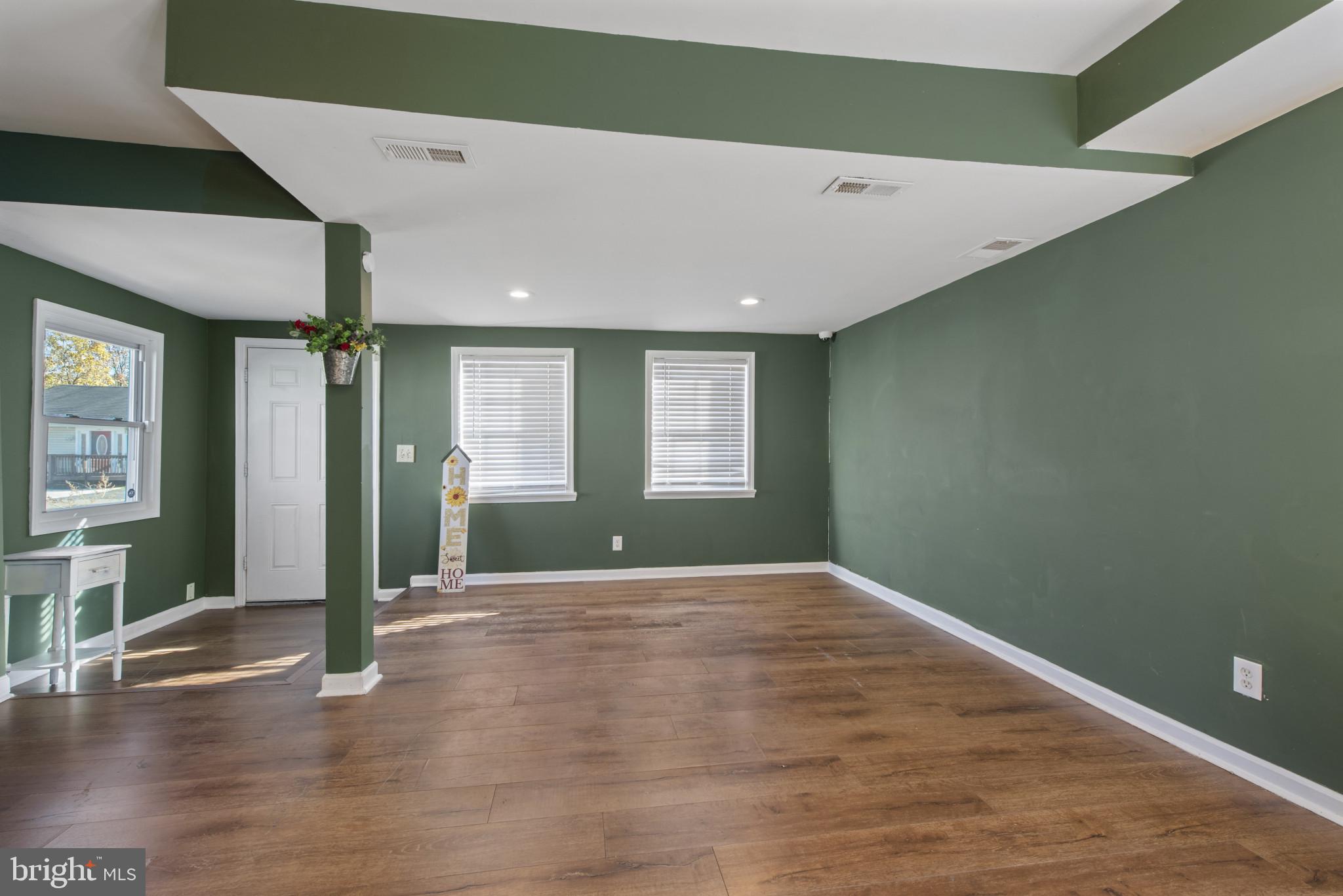 5904 Belle Grove Road Baltimore, MD 21225 - Photo 2 of 32 a view of an empty room with wooden floor and a window