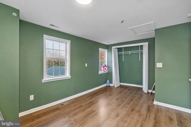 a view of empty room with window and wooden floor