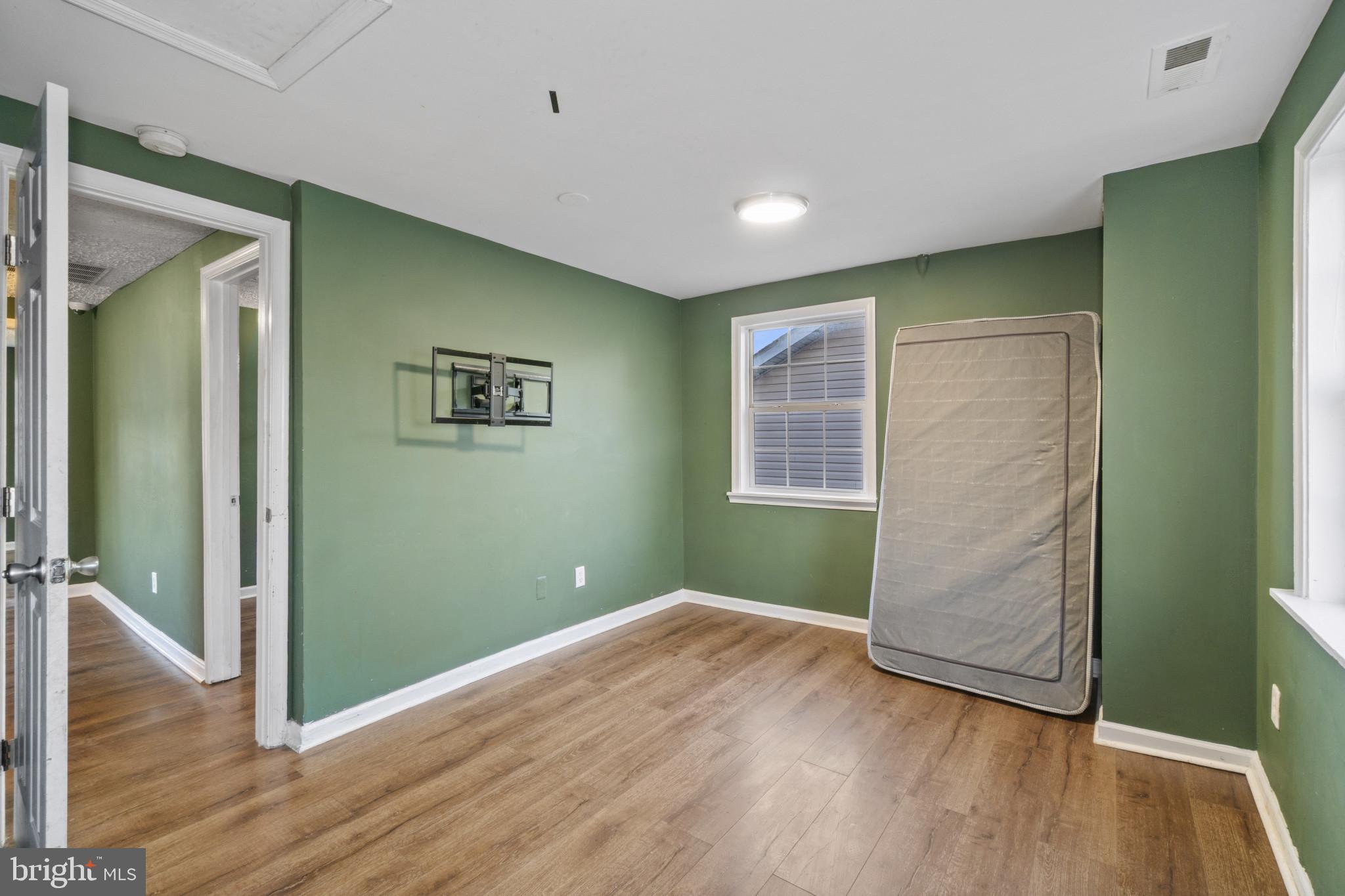 5904 Belle Grove Road Baltimore, MD 21225 - Photo 24 of 32 an empty room with wooden floor and windows