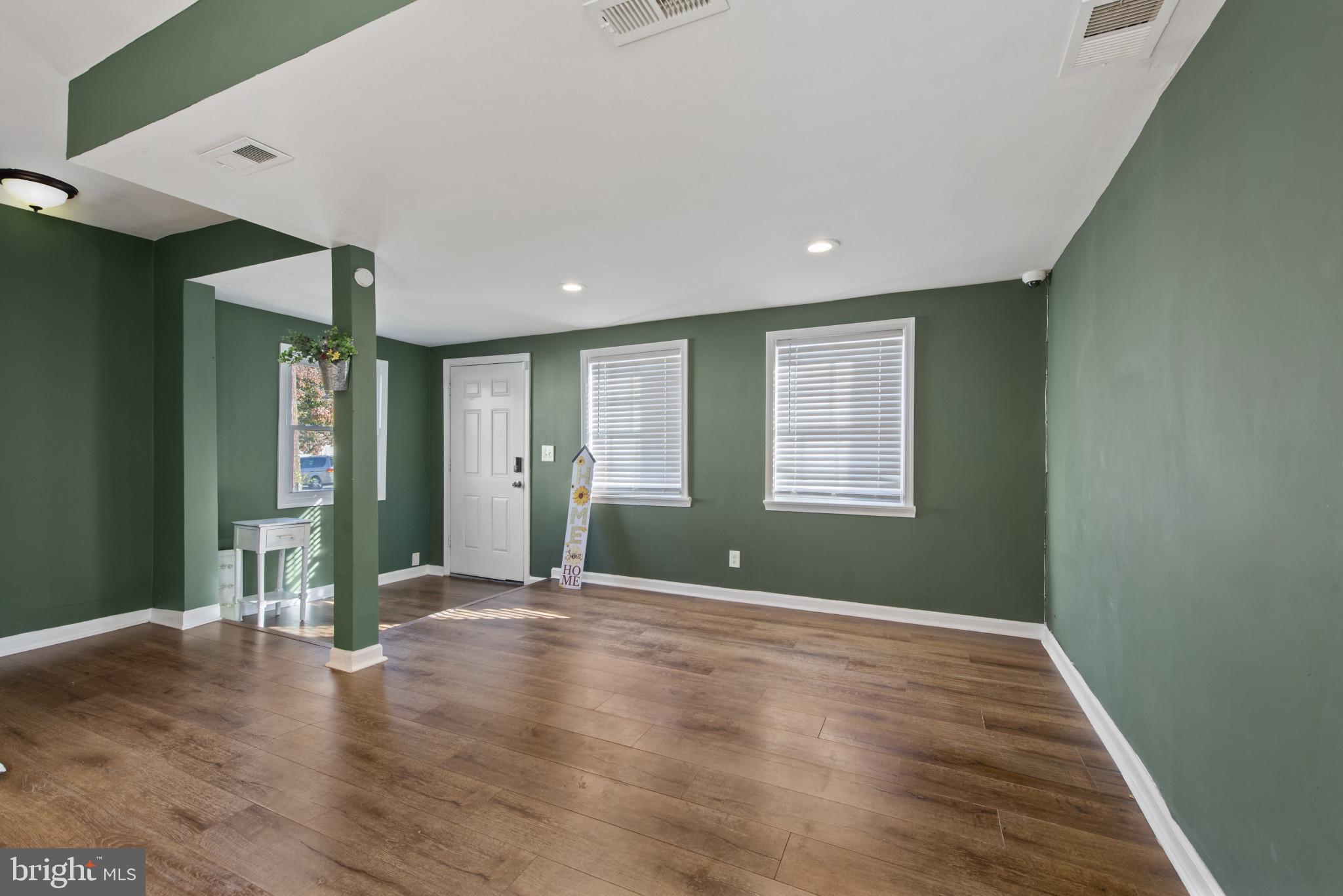 5904 Belle Grove Road Baltimore, MD 21225 - Photo 3 of 32 a view of an empty room with wooden floor and a window