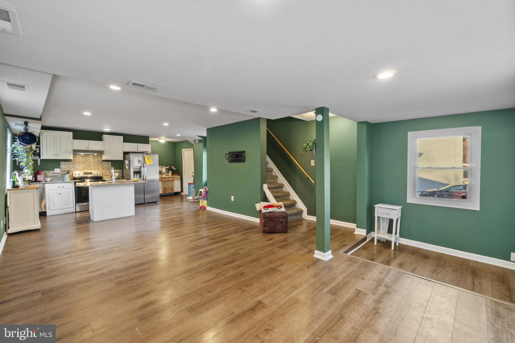 5904 Belle Grove Road Baltimore, MD 21225 - Photo 9 of 32 a view of a living room and kitchen with furniture and a wooden floor