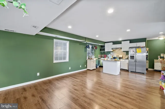 a open kitchen with cabinets and wooden floor