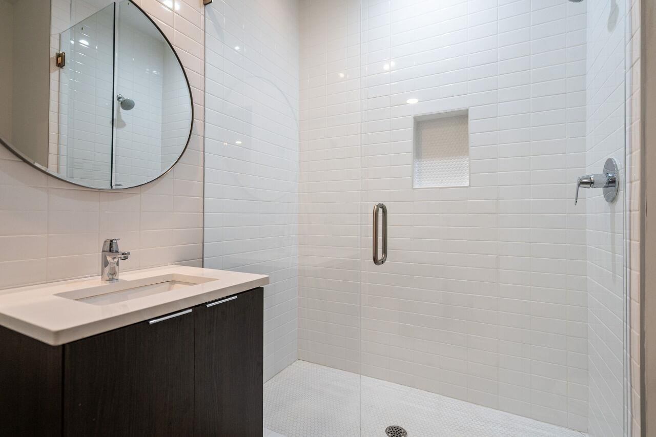 424 Chavis Way Raleigh, NC 27601 - Photo 20 of 23 a bathroom with a sink a mirror a vanity and a shower