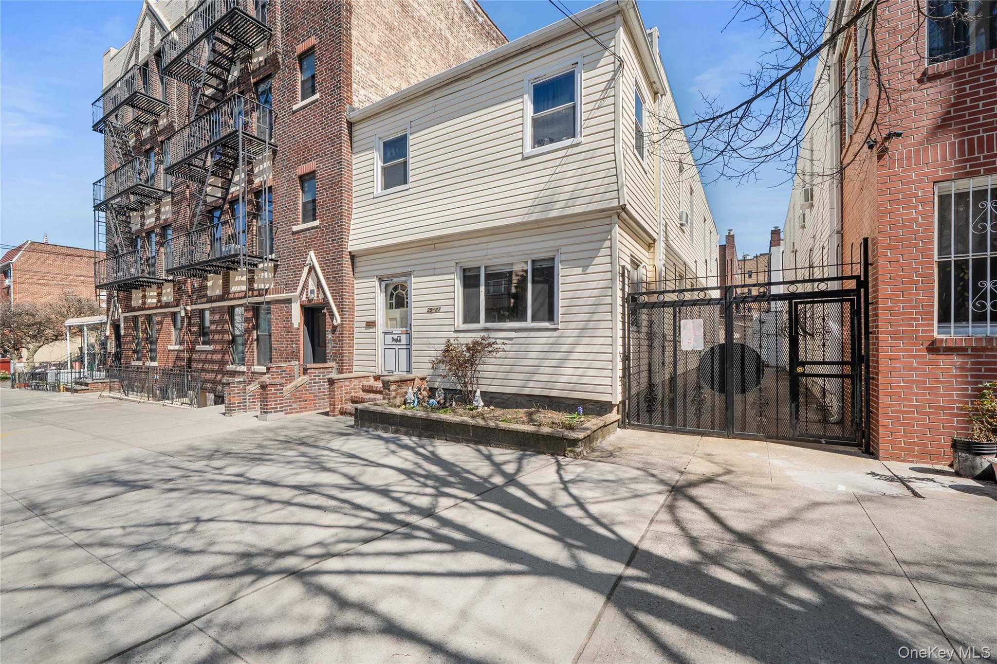 39-27 57th Street Queens, NY 11377 - Photo 28 of 35 a backyard of a house with large trees and barbeque oven
