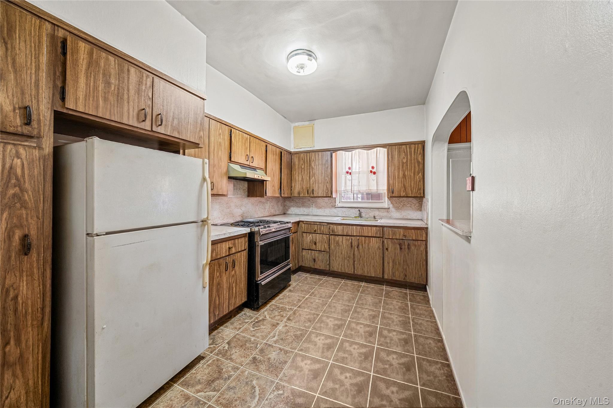 39-27 57th Street Queens, NY 11377 - Photo 3 of 35 a kitchen with stainless steel appliances a refrigerator sink and cabinets