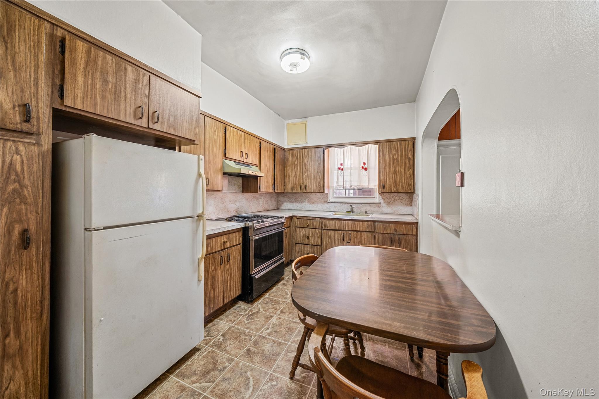 39-27 57th Street Queens, NY 11377 - Photo 4 of 35 a kitchen with stainless steel appliances granite countertop a refrigerator a stove a sink dishwasher with a dining table and chairs