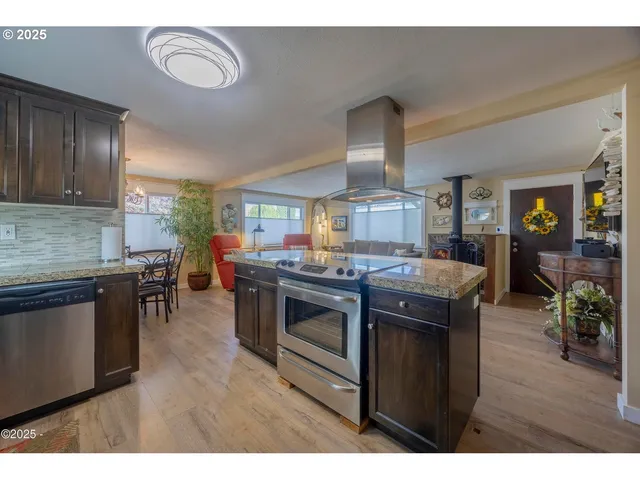 a kitchen with stainless steel appliances granite countertop a stove a sink and a refrigerator