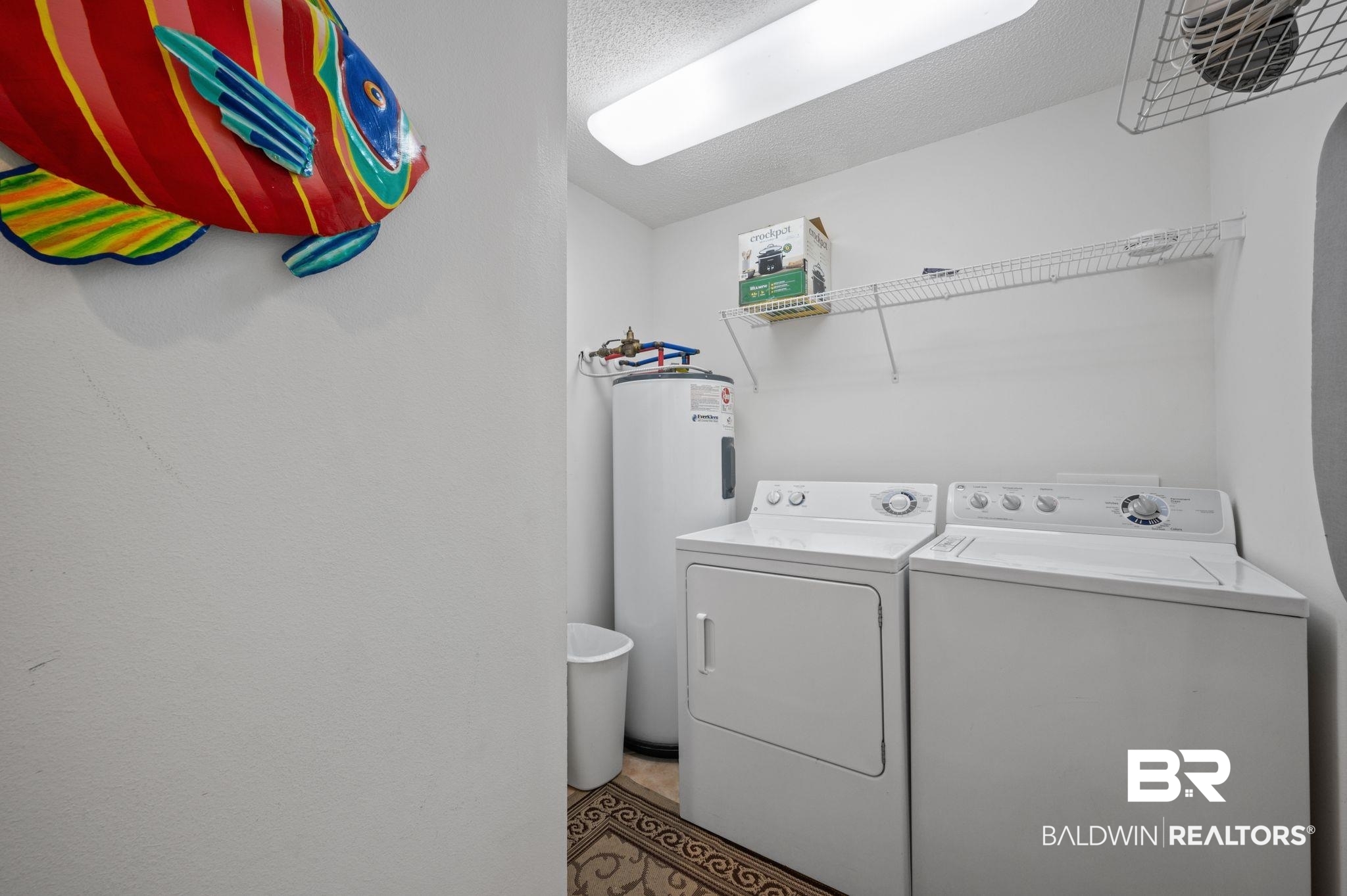 27580 Canal Road, Unit 1427 Orange Beach, AL 36561 - Photo 28 of 38 Laundry room with water heater, washing machine and clothes dryer, and a textured ceiling