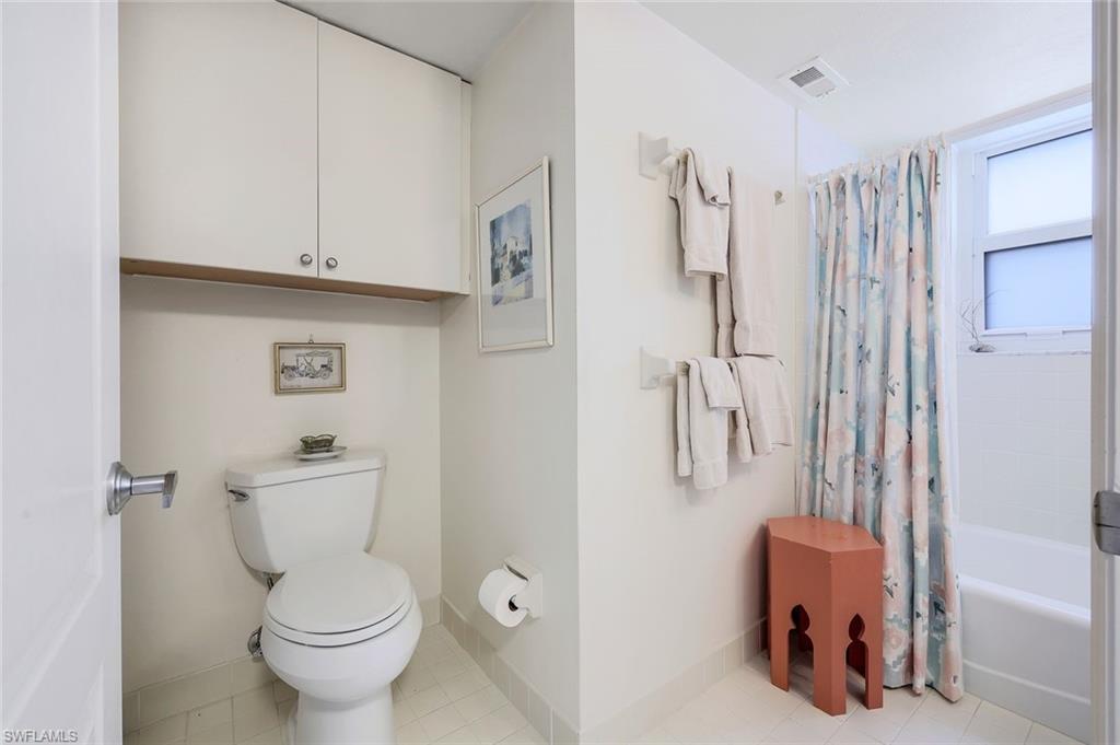 5501 Heron Point Drive, Unit 204 Naples, FL 34108 - Photo 14 of 23 a white toilet sitting next to a bathroom sink