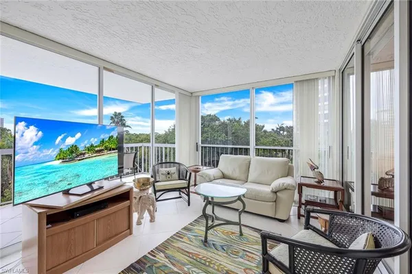 a living room with patio furniture and a yard
