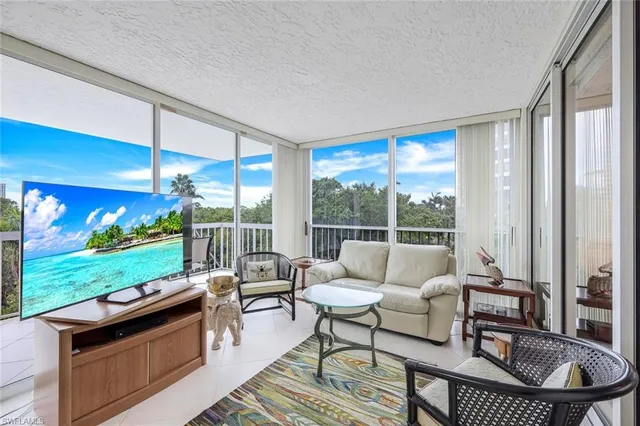 a living room with patio furniture and a yard