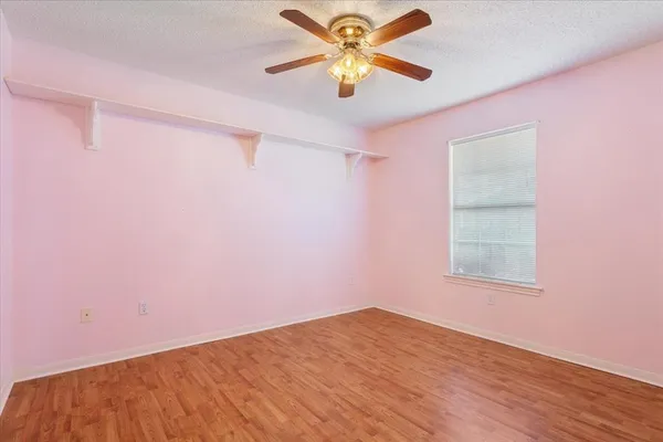 a view of a big room with wooden floor and a chandelier fan