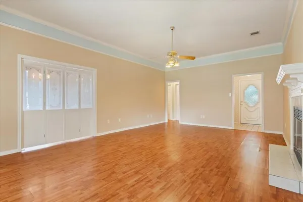 a view of an empty room with window and wooden floor