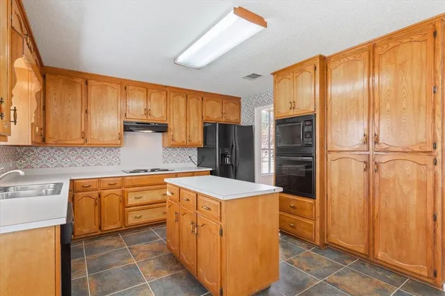 a kitchen with stainless steel appliances granite countertop a refrigerator a sink and dishwasher