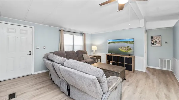 a living room with furniture and a wooden floor