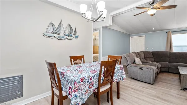 a living room with furniture a dining table and a chandelier
