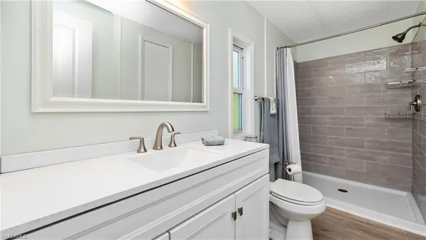 a bathroom with a sink a toilet and shower