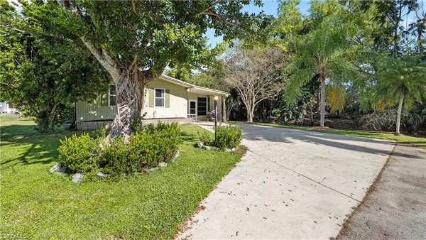 a front view of a house with a yard and potted plants
