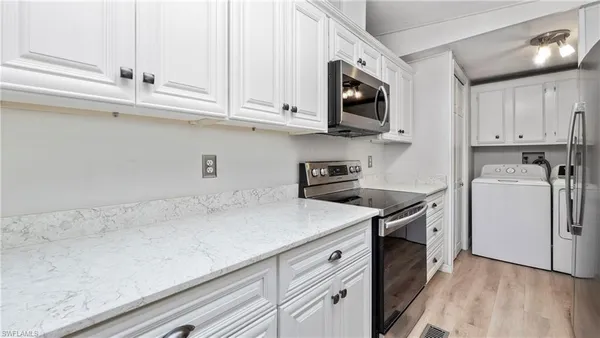 a kitchen with stainless steel appliances granite countertop a sink a stove and a microwave