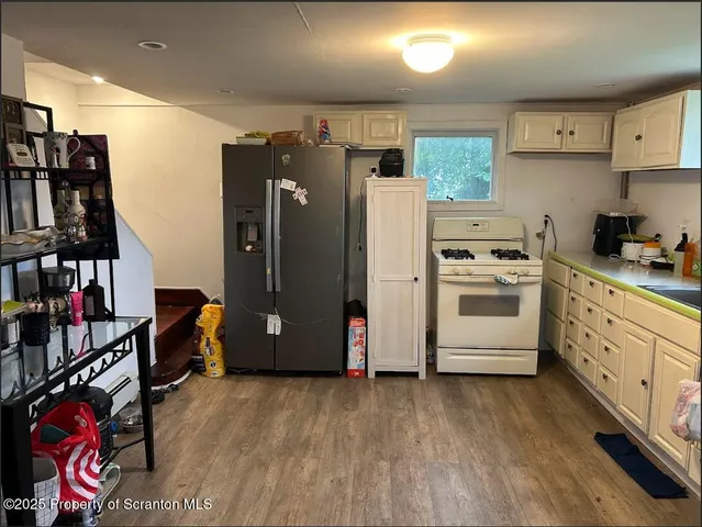 a kitchen with cabinets a refrigerator and a stove top oven