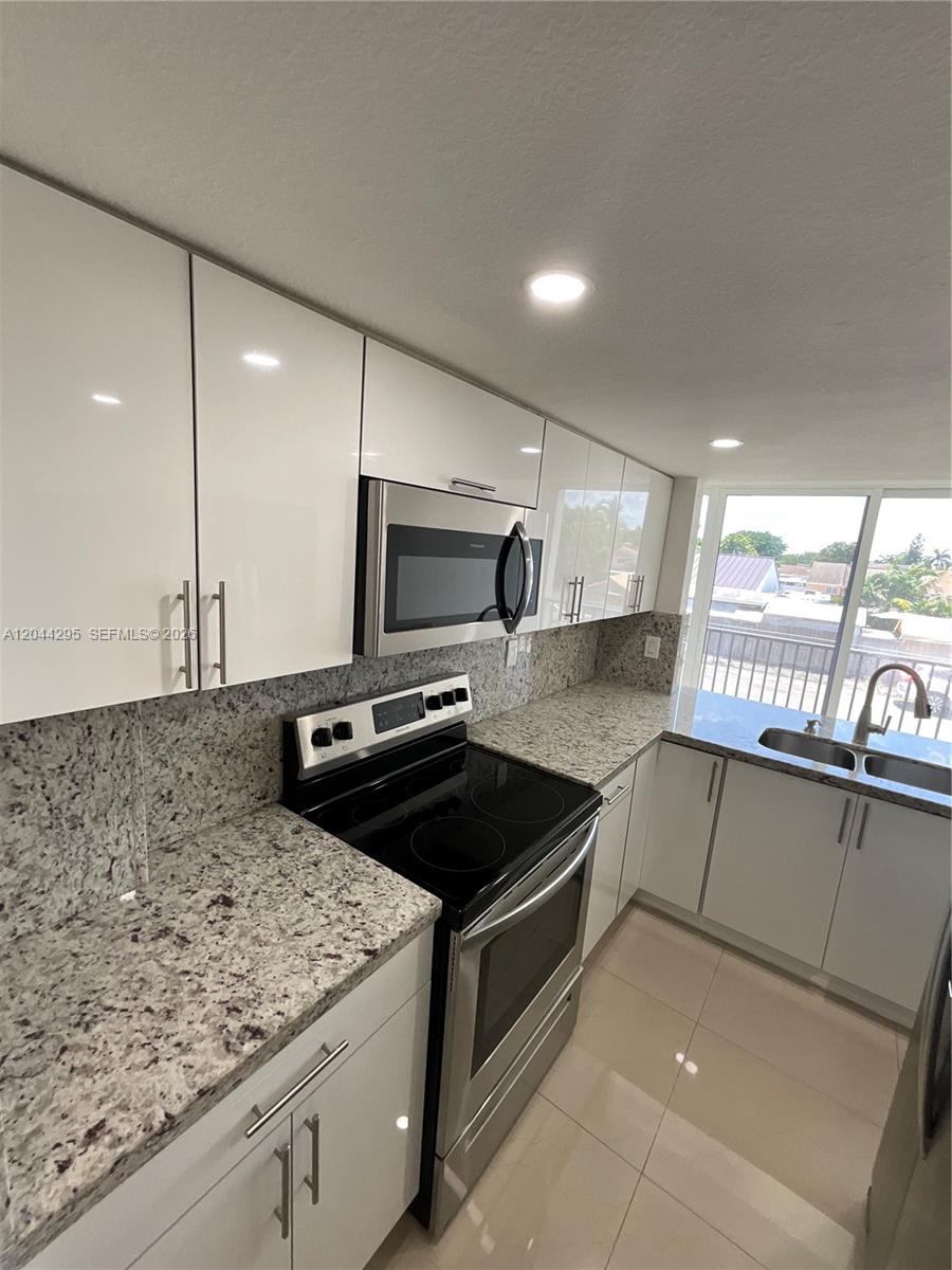 9441 Southwest 4th Street, Unit 214 Miami, FL 33174 - Photo 3 of 22 a kitchen with stainless steel appliances granite countertop a sink and a stove