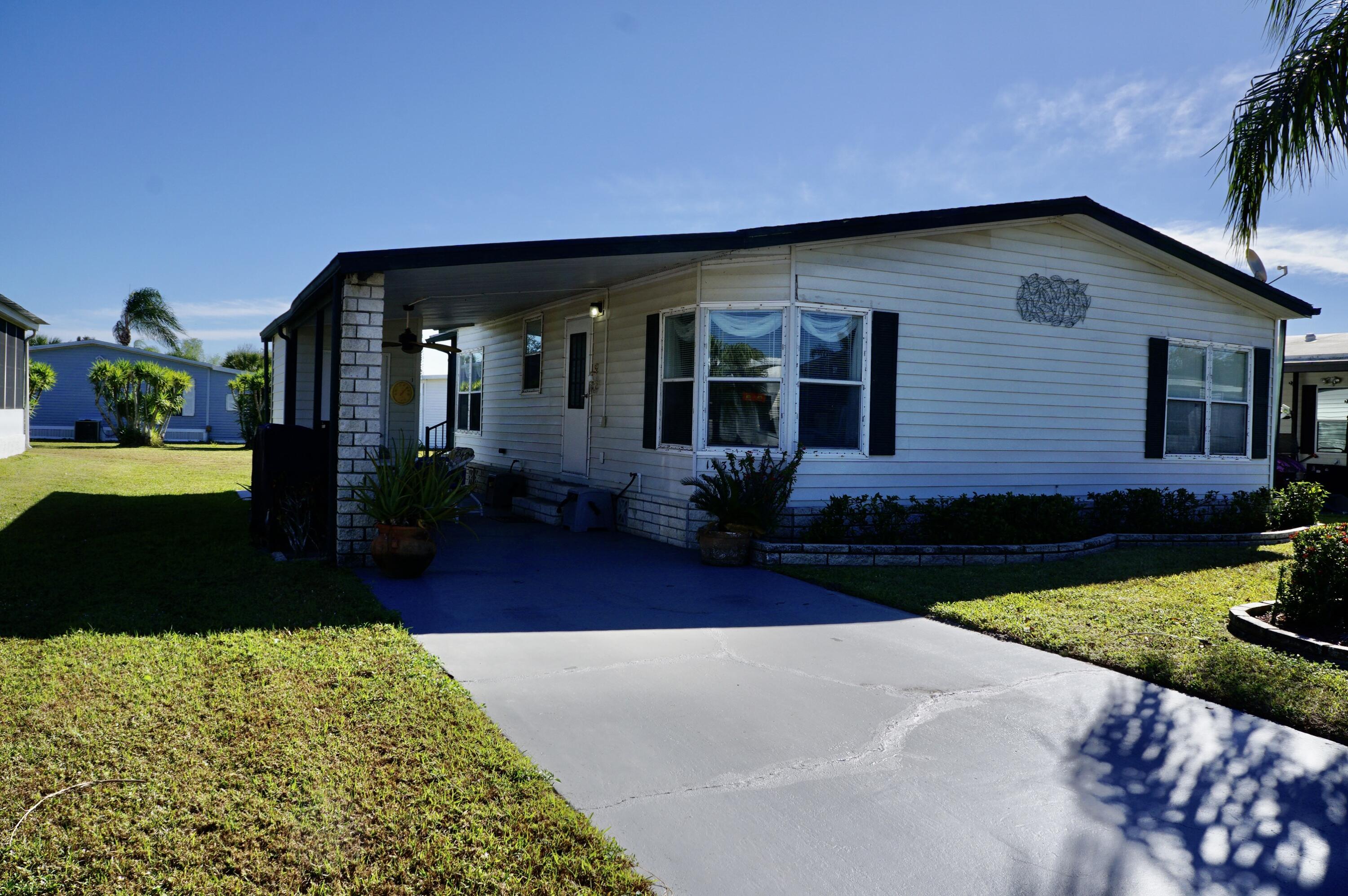 14333 Azucena Court Fort Pierce, FL 34951 - Photo 2 of 28 a front view of a house with garden