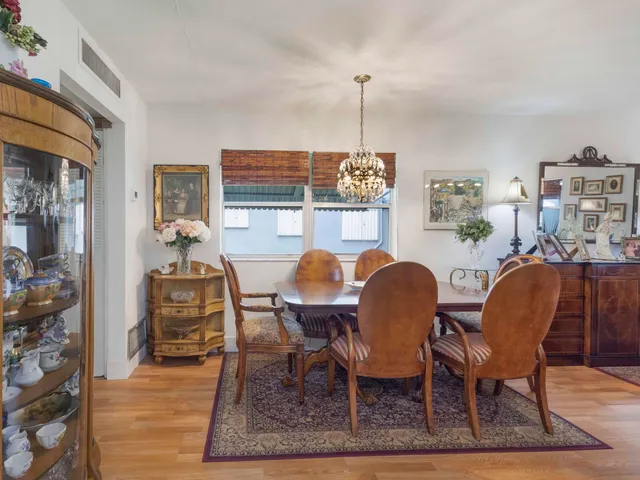 a dining room with furniture a chandelier and wooden floor