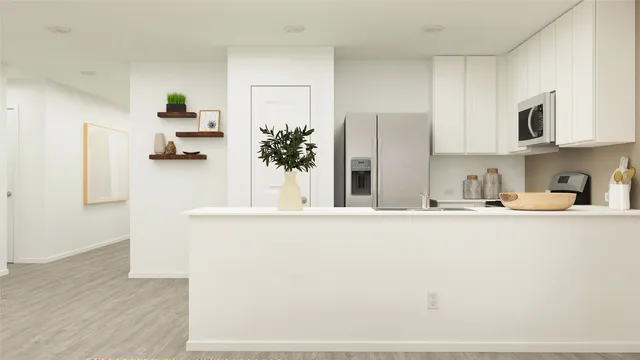 a kitchen with stainless steel appliances a refrigerator a sink and white cabinets
