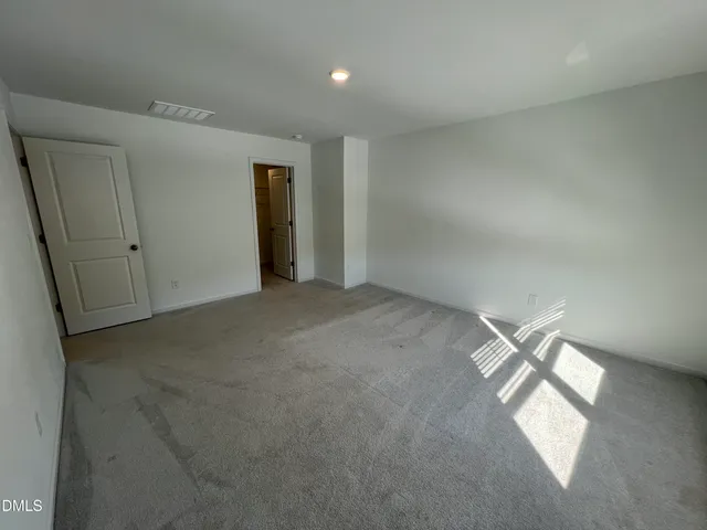 an empty room with a windows and closet