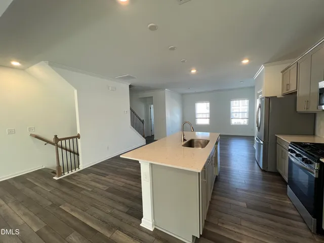 a kitchen with a sink and wooden floor